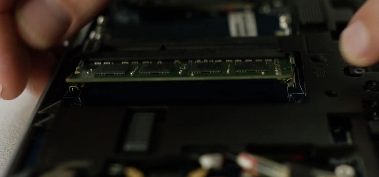노트북에서 Crucial RAM 모듈을 제거하기 위해 측면 클립을 풀고 있는 사람